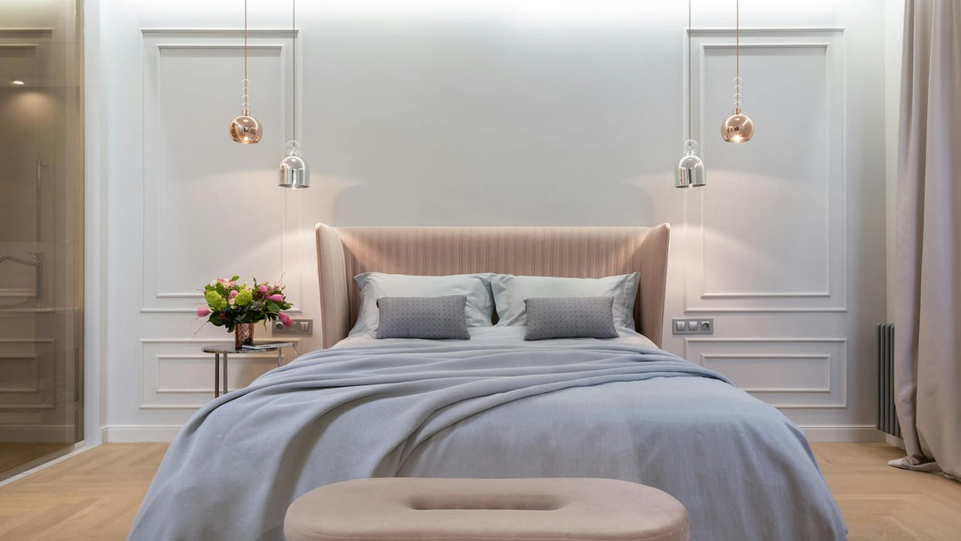 Elegant, serene luxury bedroom with soft blue-grey hypoallergenic bedding and a blush headboard — perfect sleep environment for allergy sufferers
