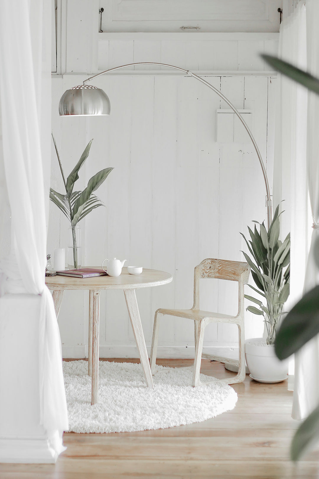 A single luxury white pillow with fresh eucalyptus on a neatly made bed in cool natural morning light