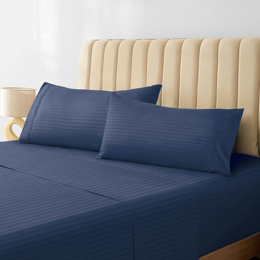 a bed with a blue sheet and pillows