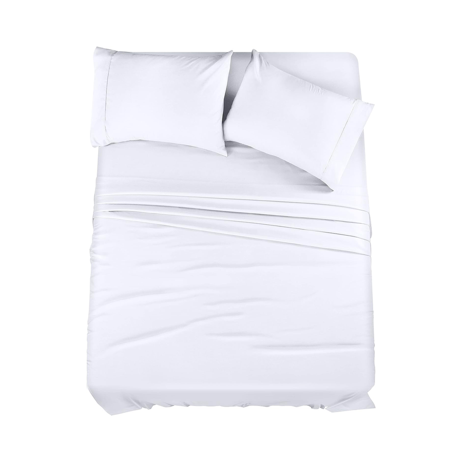 a bed with white sheets and pillows