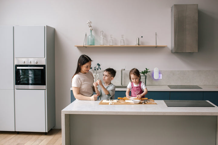 a person and kids sitting at a kitchen counter