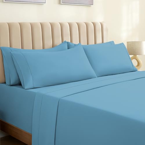 a bed with blue sheets and pillows