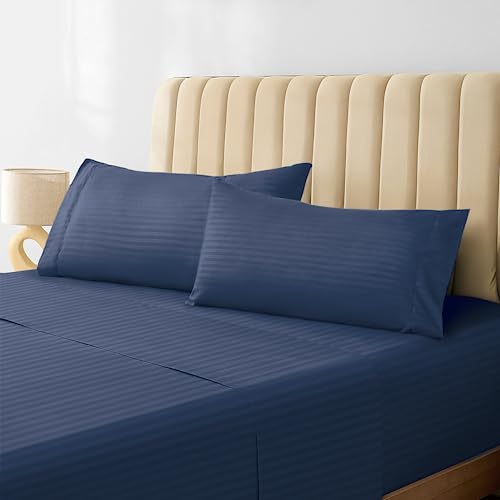a bed with blue sheets and pillows
