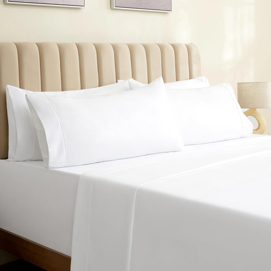 a bed with white sheets and a lamp