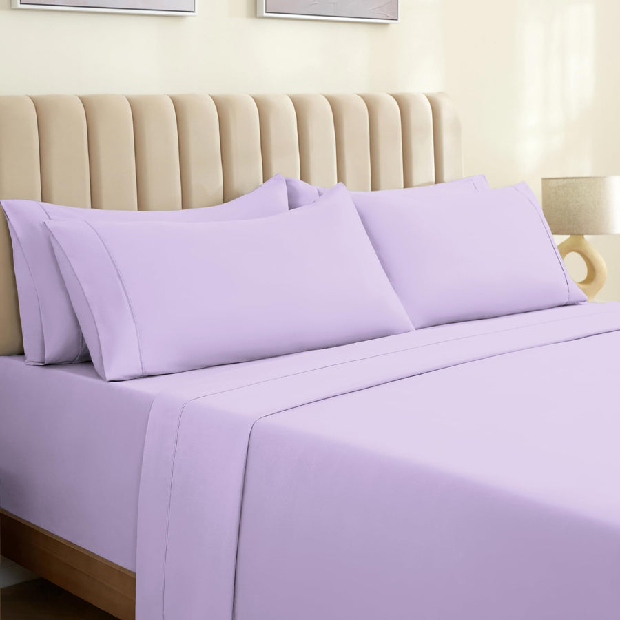 a bed with purple sheets and pillows