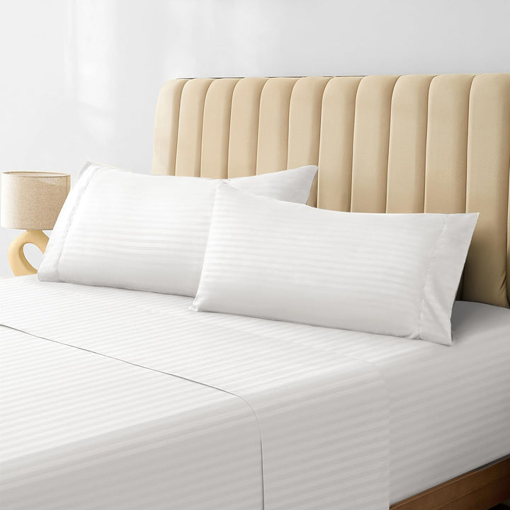 a bed with white sheets and pillows