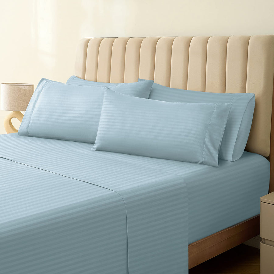 a bed with a blue sheet and pillows